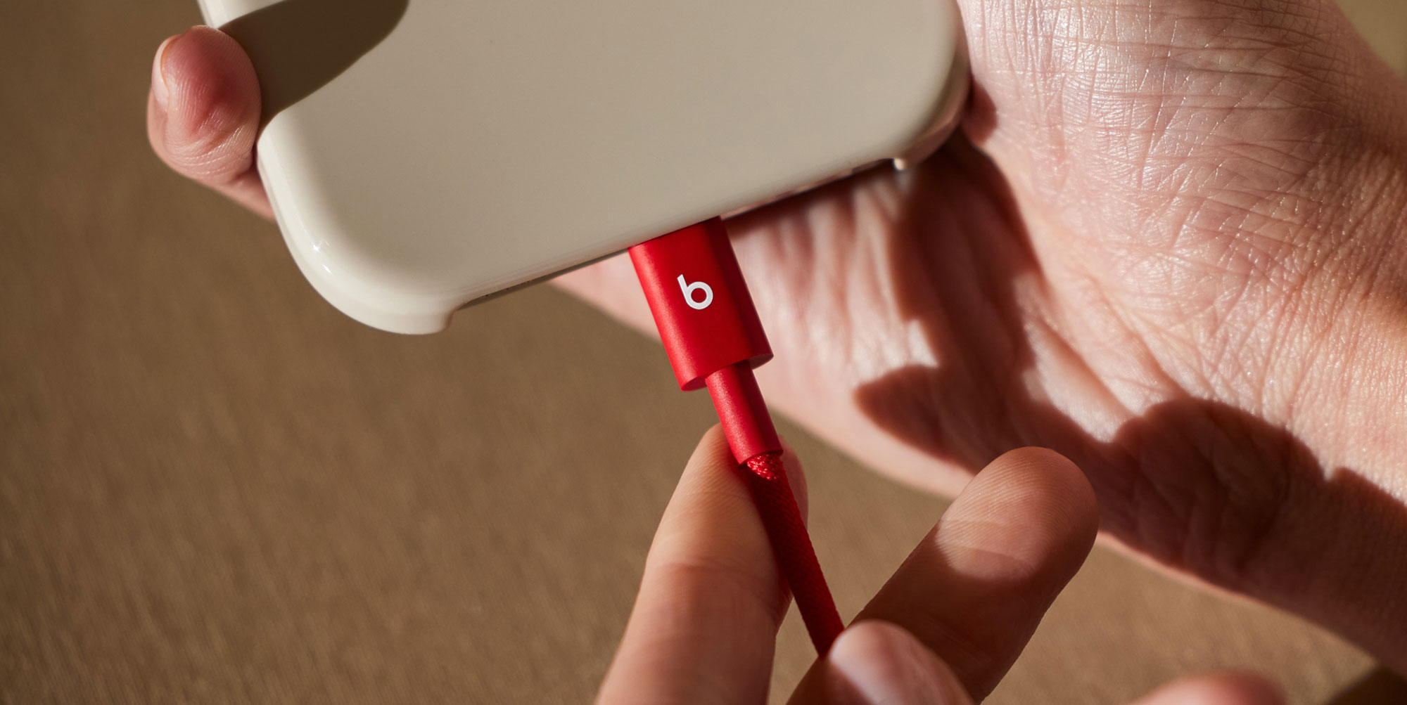 一人将 Beats USB-C 转 USB-C 编织连接线插入兼容设备。